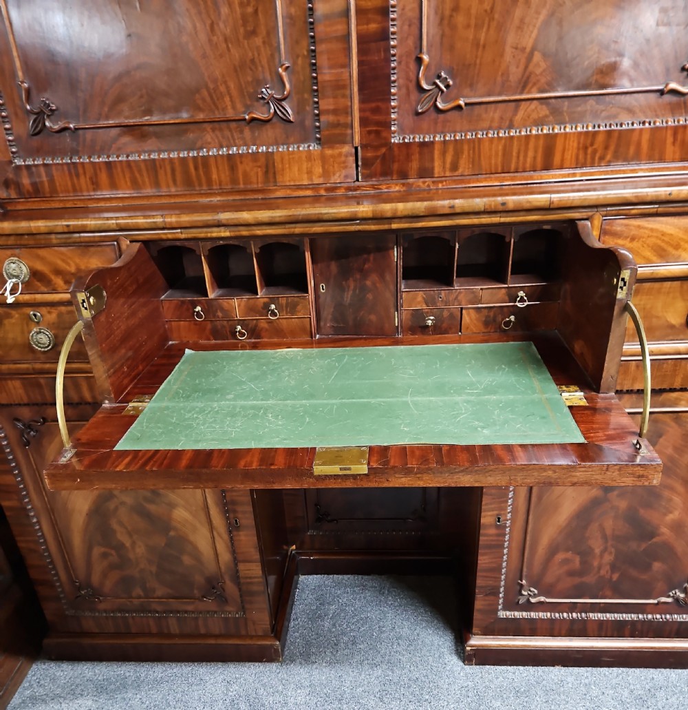 A William IV mahogany secretary bookcase featuring a two-door upper section, a central secretary drawer, and a lower kneehole flanked by cupboards with spirally turned columns. View V