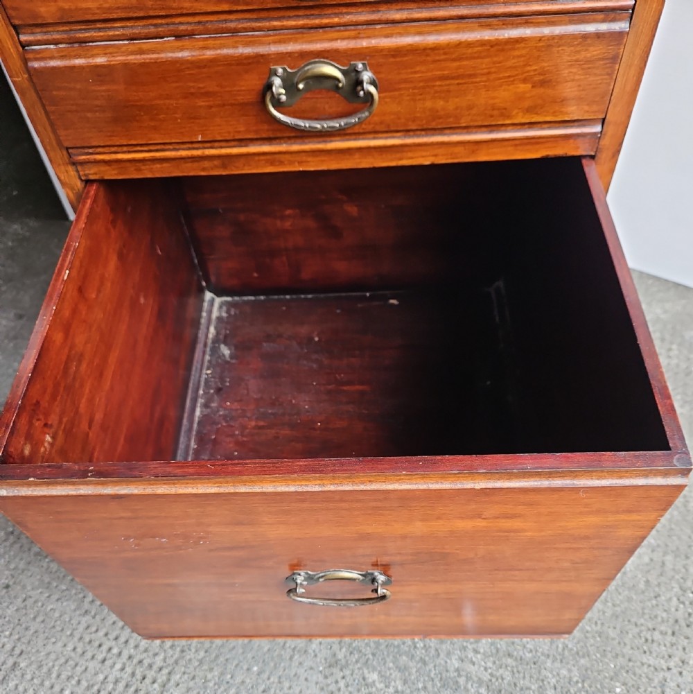 A tall mahogany sheet music cabinet featuring seven drawers with brass drop handles and a gallery top. View IV