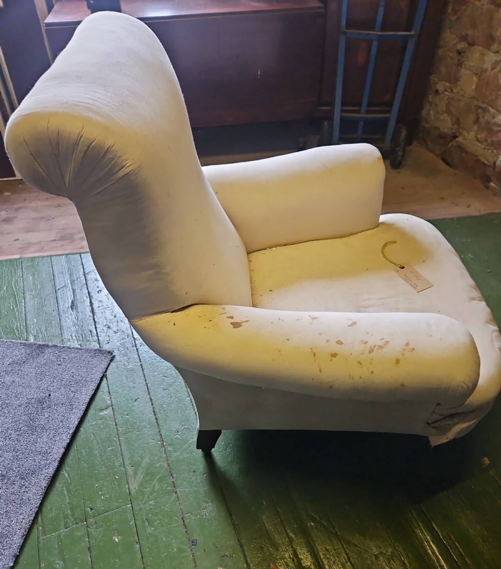 A deep-seated Howard style armchair upholstered in off-white calico fabric with low padded arms. View II