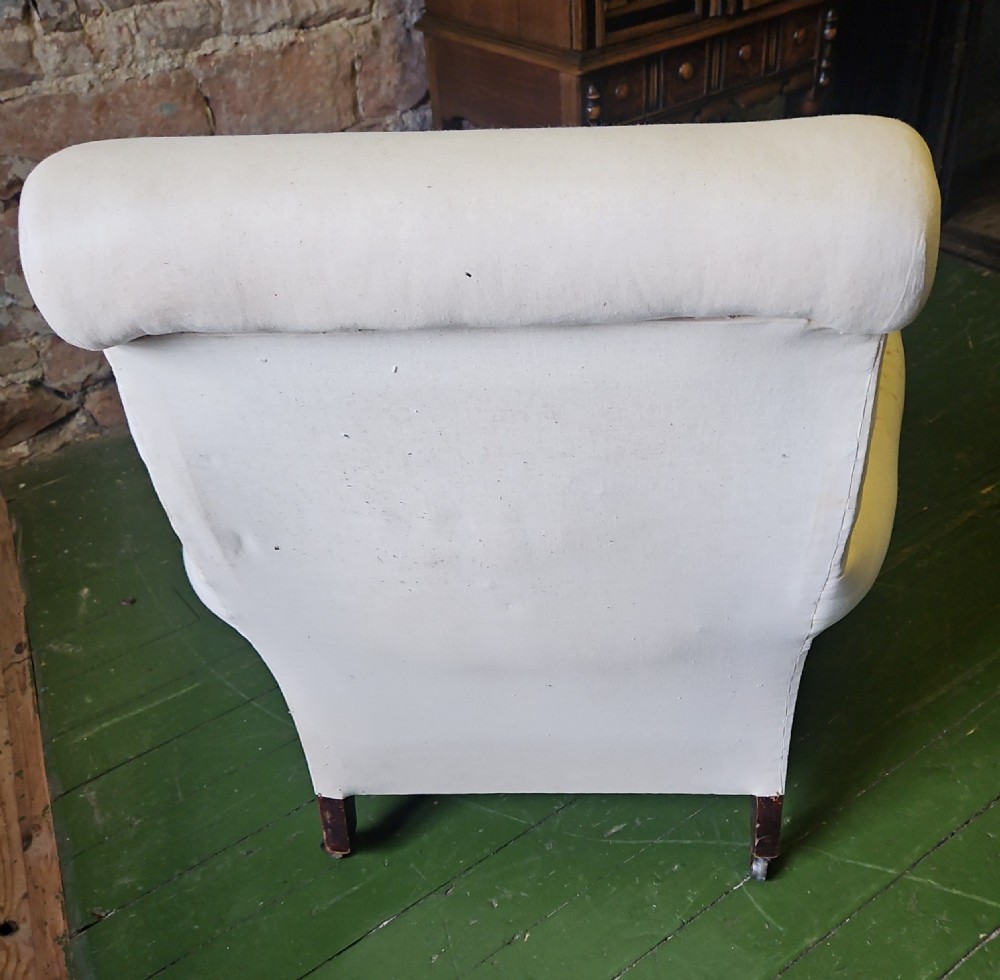 A deep-seated Howard style armchair upholstered in off-white calico fabric with low padded arms. View VI