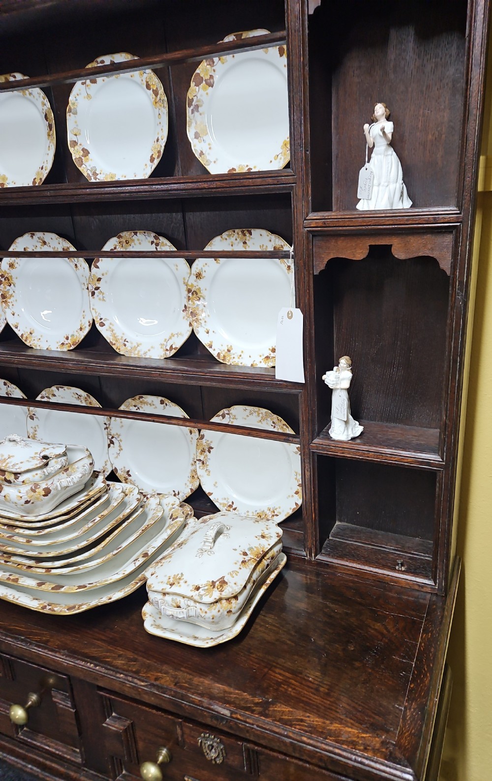 A dark oak Welsh dresser featuring a tall multi-tiered open plate rack top above three drawers with geometric mouldings and turned legs. View IV