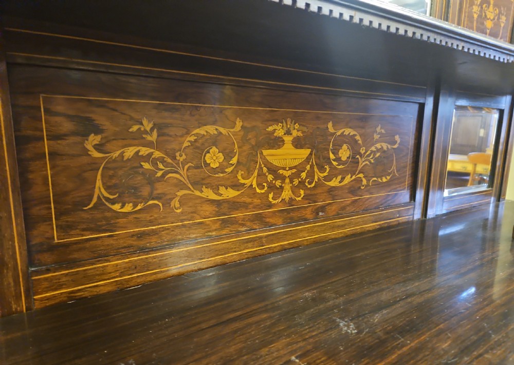An Edwardian rosewood cabinet featuring intricate marquetry inlay, multiple mirrored panels, open tier shelving, and central glass-front doors. View II