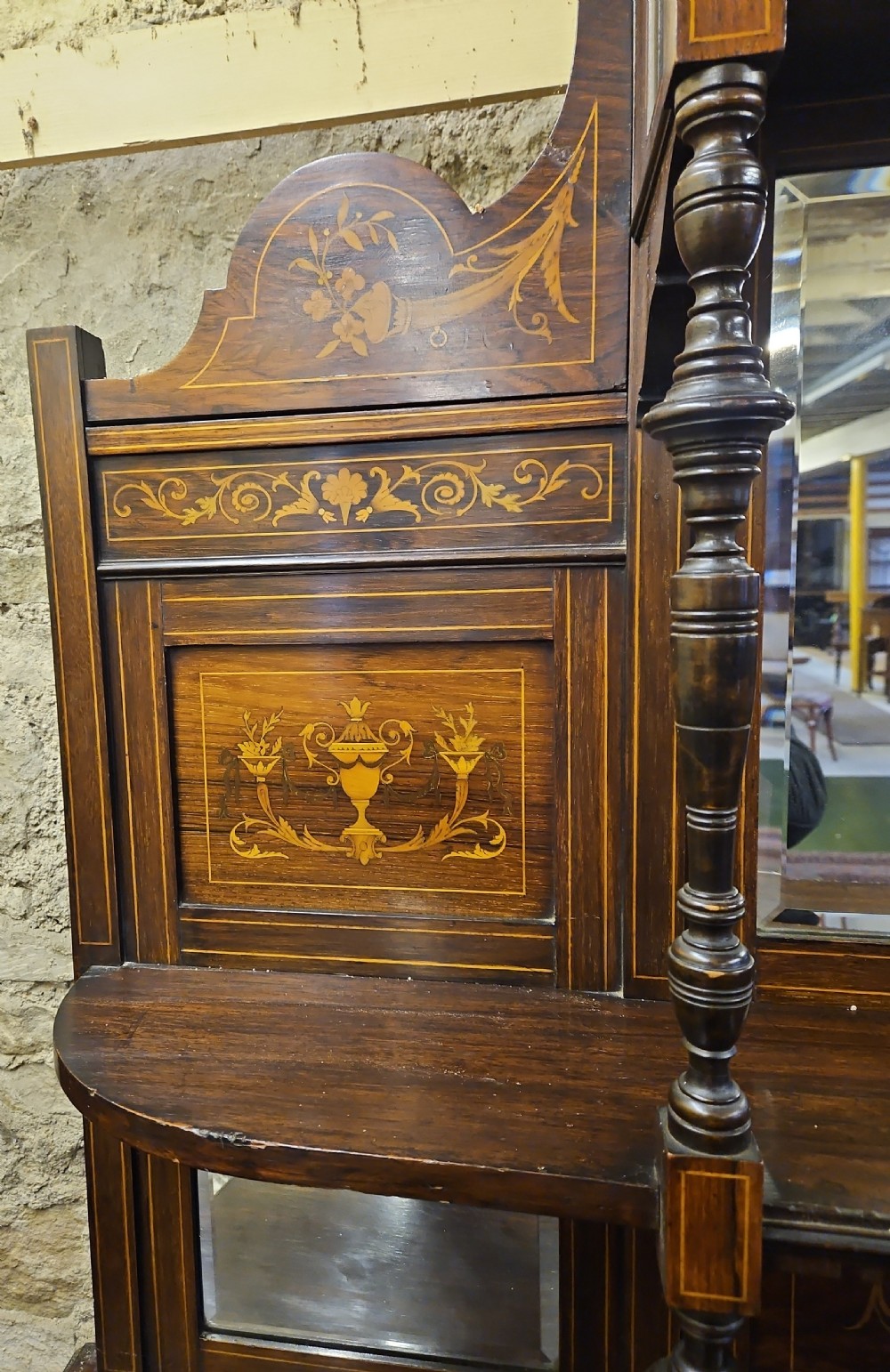 An Edwardian rosewood cabinet featuring intricate marquetry inlay, multiple mirrored panels, open tier shelving, and central glass-front doors. View IV