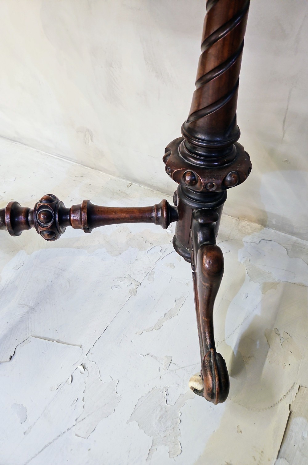 A Victorian walnut work table featuring spiral-turned twin supports, a carved central stretcher, and shaped feet resting on white porcelain castors. View II