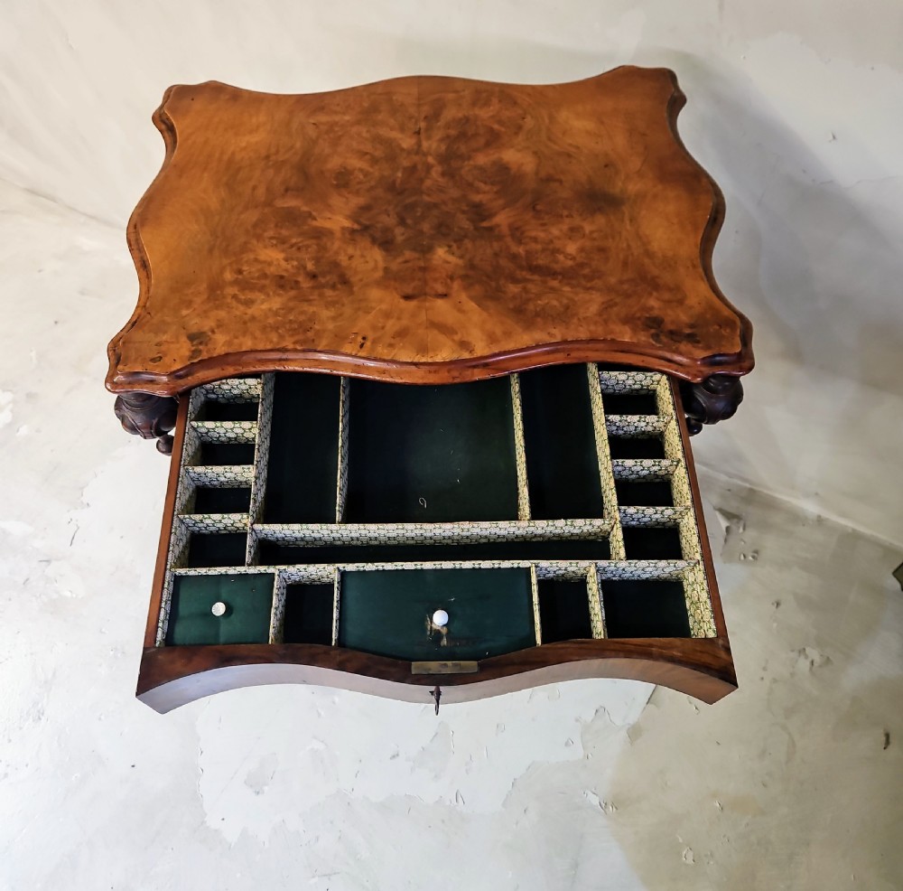 A Victorian walnut work table featuring spiral-turned twin supports, a carved central stretcher, and shaped feet resting on white porcelain castors. View VII