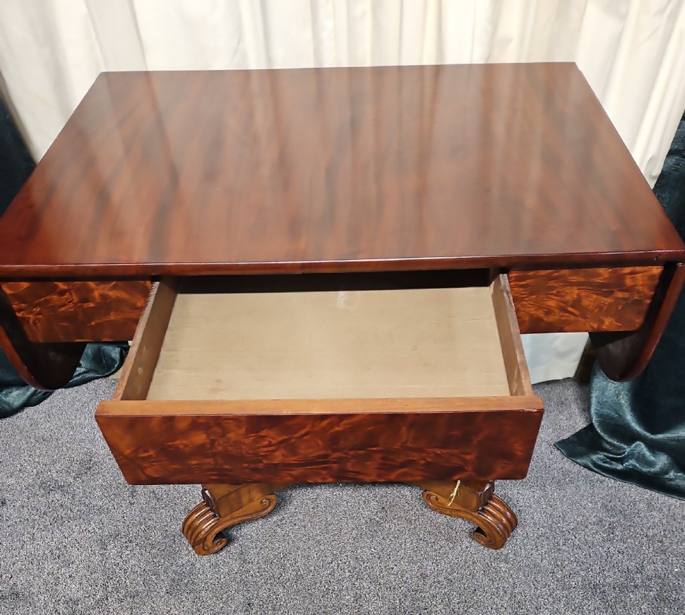 A Victorian mahogany drop-leaf sofa table with burr walnut veneered drawers, turned twin-column legs, and a shaped quadruped base on castors. View II