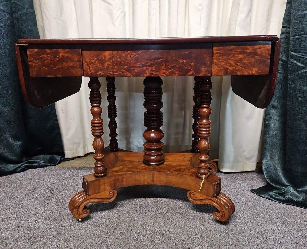 A Victorian mahogany drop-leaf sofa table with burr walnut veneered drawers, turned twin-column legs, and a shaped quadruped base on castors. View VII