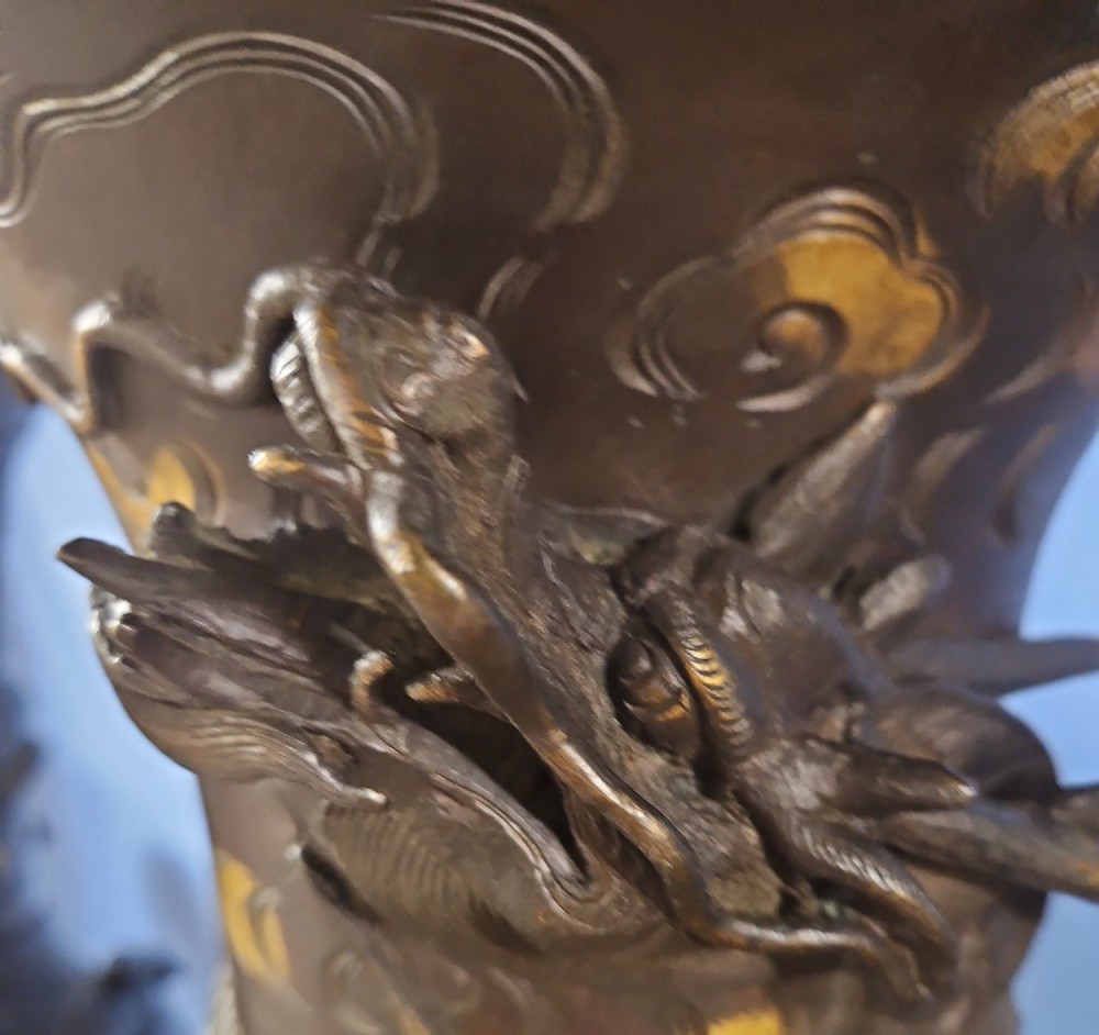 A pair of large Japanese bronze vases featuring high-relief sculpted dragons around the necks and crane motifs on bulbous bases with gilt detailing. View III