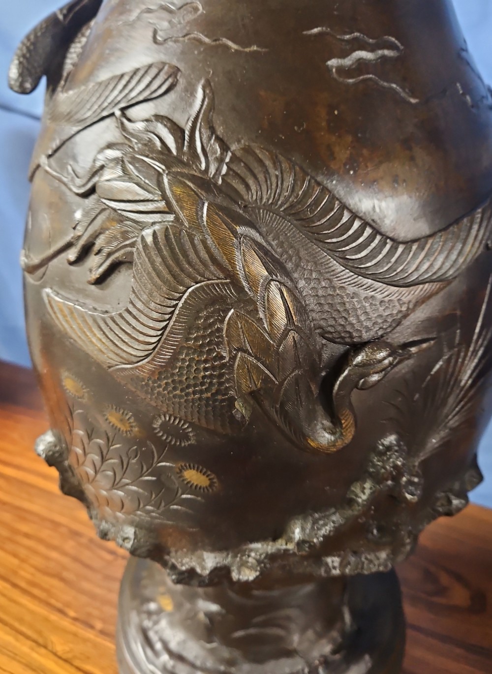 A pair of large Japanese bronze vases featuring high-relief sculpted dragons around the necks and crane motifs on bulbous bases with gilt detailing. View X