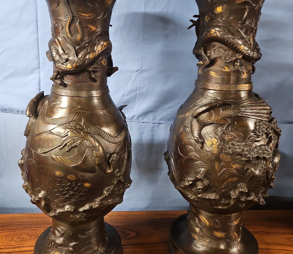 A pair of large Japanese bronze vases featuring high-relief sculpted dragons around the necks and crane motifs on bulbous bases with gilt detailing. View XI