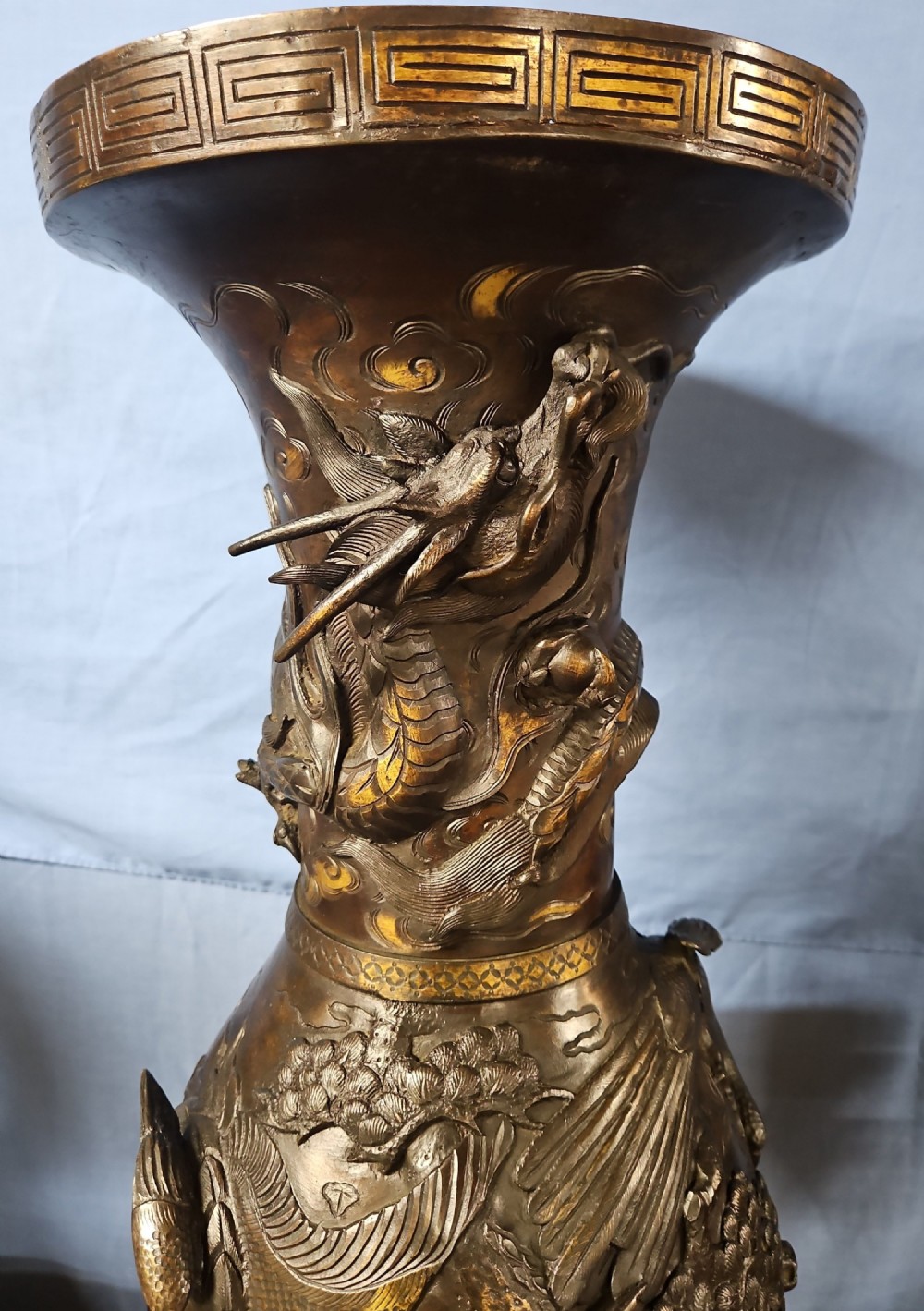 A pair of large Japanese bronze vases featuring high-relief sculpted dragons around the necks and crane motifs on bulbous bases with gilt detailing. View XV