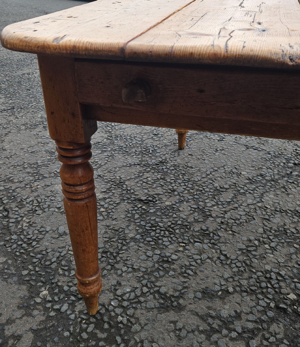 A rectangular Victorian pine table featuring a multi-plank top with visible grain patterns and four turned wooden legs. View V