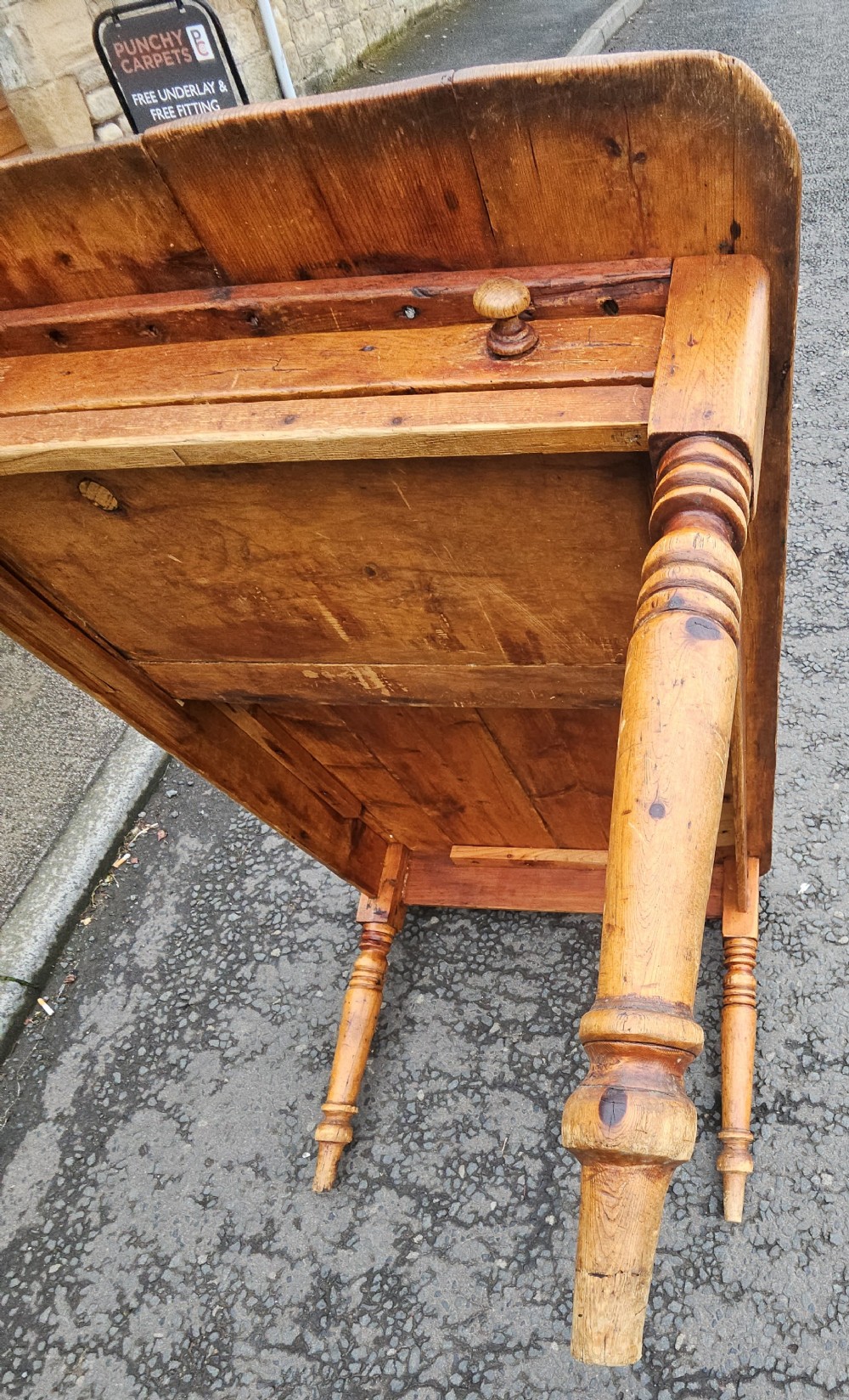 A rectangular Victorian pine table featuring a multi-plank top with visible grain patterns and four turned wooden legs. View VI