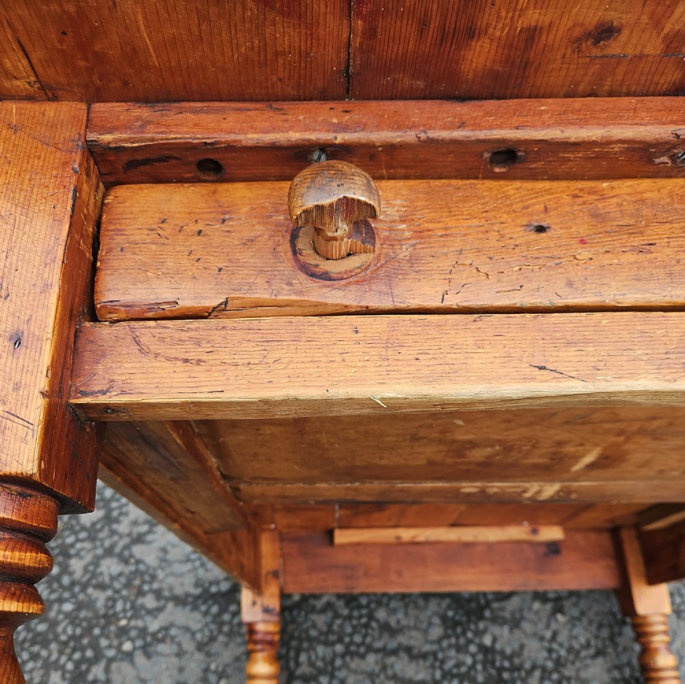 A rectangular Victorian pine table featuring a multi-plank top with visible grain patterns and four turned wooden legs. View VIII
