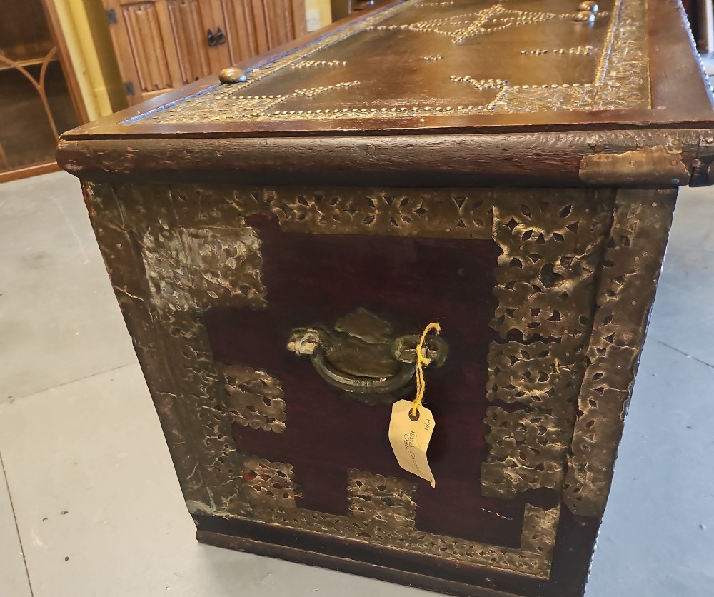 A mid-Victorian wooden Zanzibar chest decorated with intricate brass studs, geometric brass sheeting, and three base drawers. View II