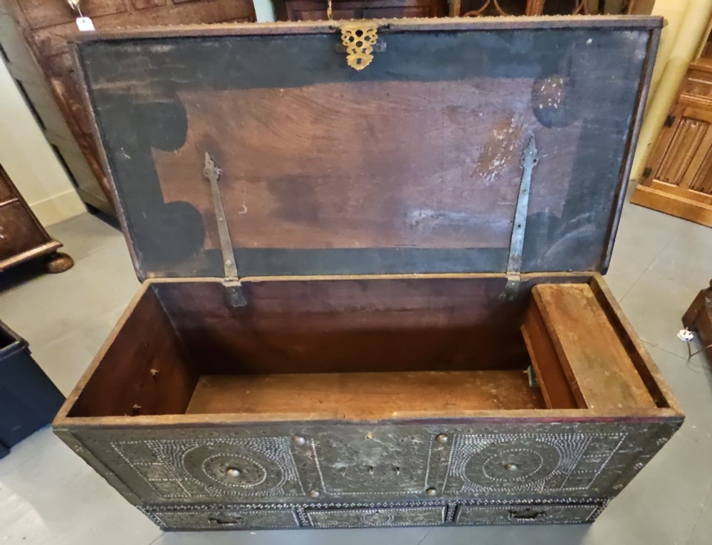 A mid-Victorian wooden Zanzibar chest decorated with intricate brass studs, geometric brass sheeting, and three base drawers. View XI