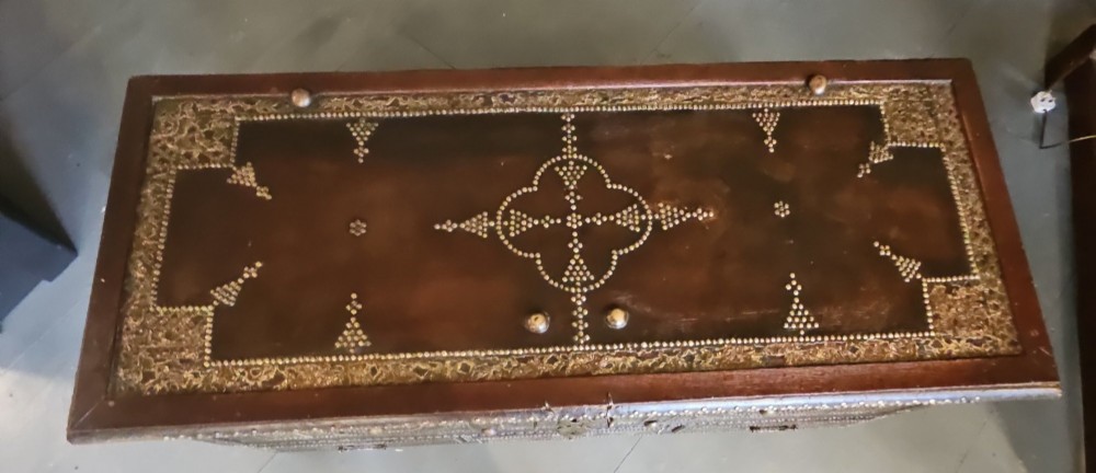 A mid-Victorian wooden Zanzibar chest decorated with intricate brass studs, geometric brass sheeting, and three base drawers. View XIV