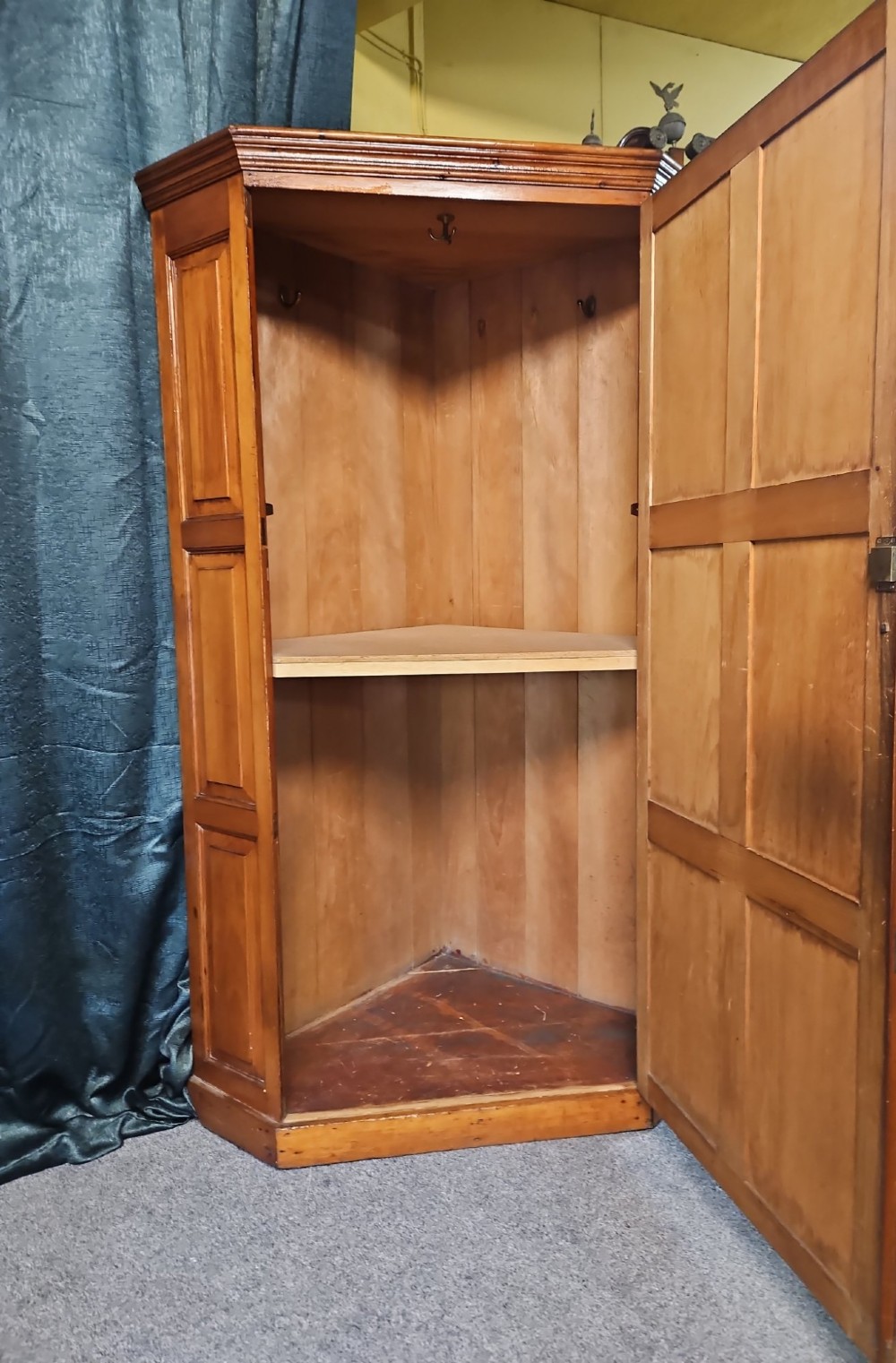 A tall Victorian pine corner wardrobe with fielded panel doors, a brass escutcheon, and a moulded cornice. View VII