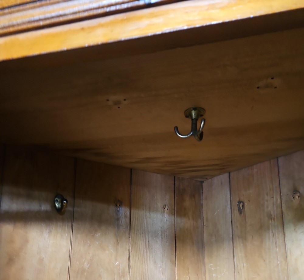 A tall Victorian pine corner wardrobe with fielded panel doors, a brass escutcheon, and a moulded cornice. View VIII