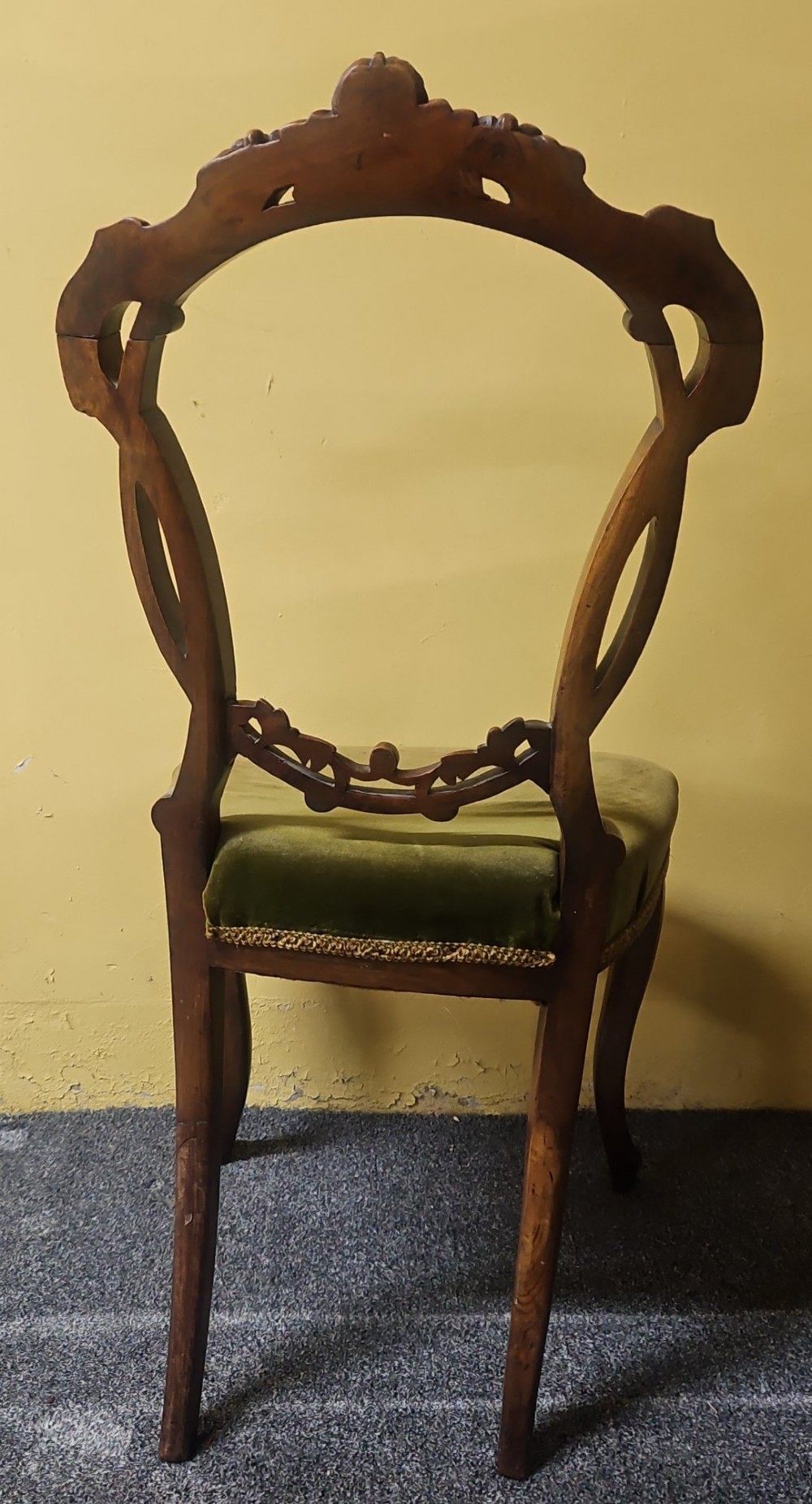 A pair of Victorian carved walnut balloon-back side chairs featuring olive green velvet upholstered seats and front cabriole legs. View V