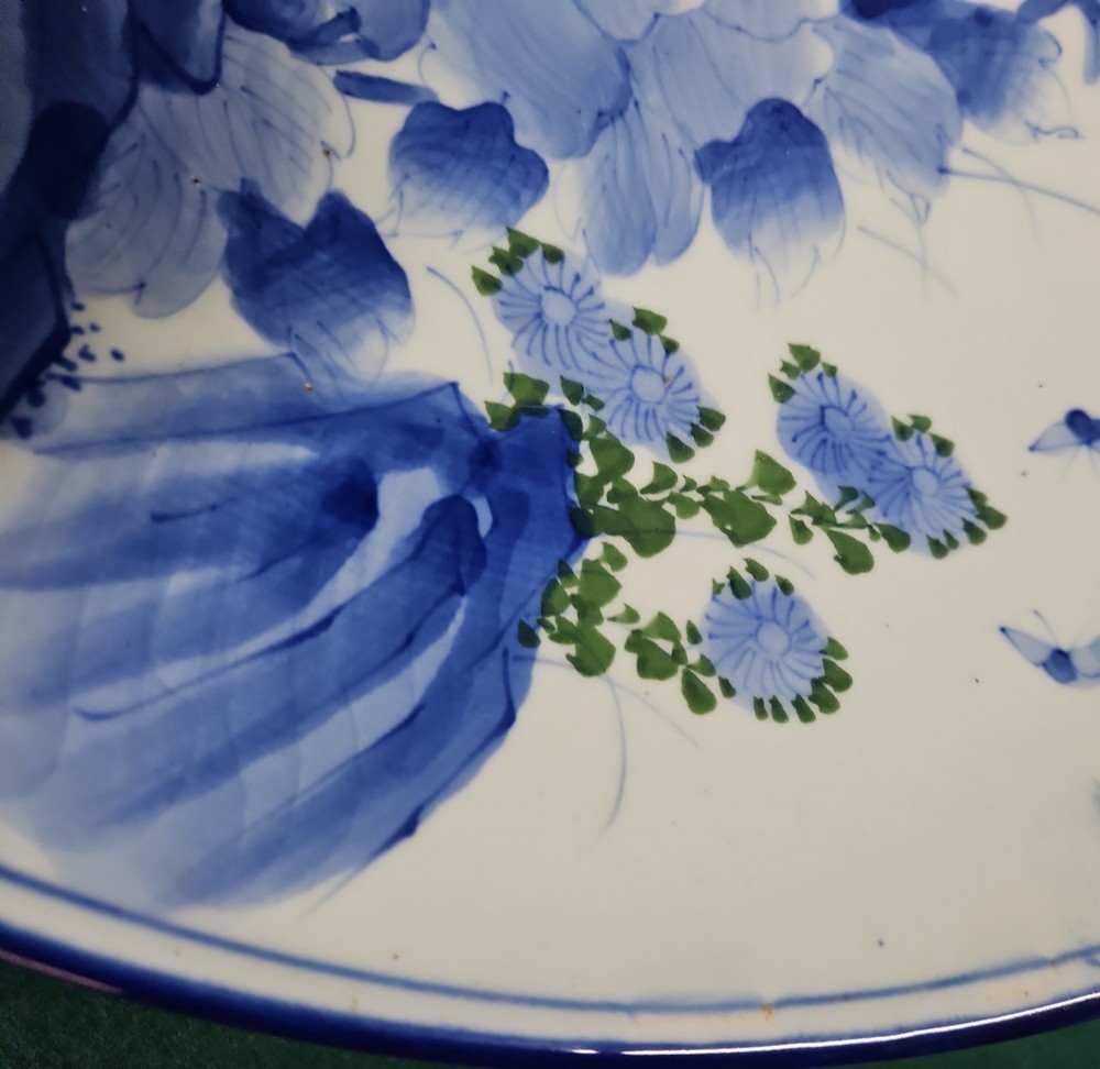 A circular blue and white Japanese Arita porcelain charger decorated with a flowering prunus branch and chrysanthemum blossoms. View III