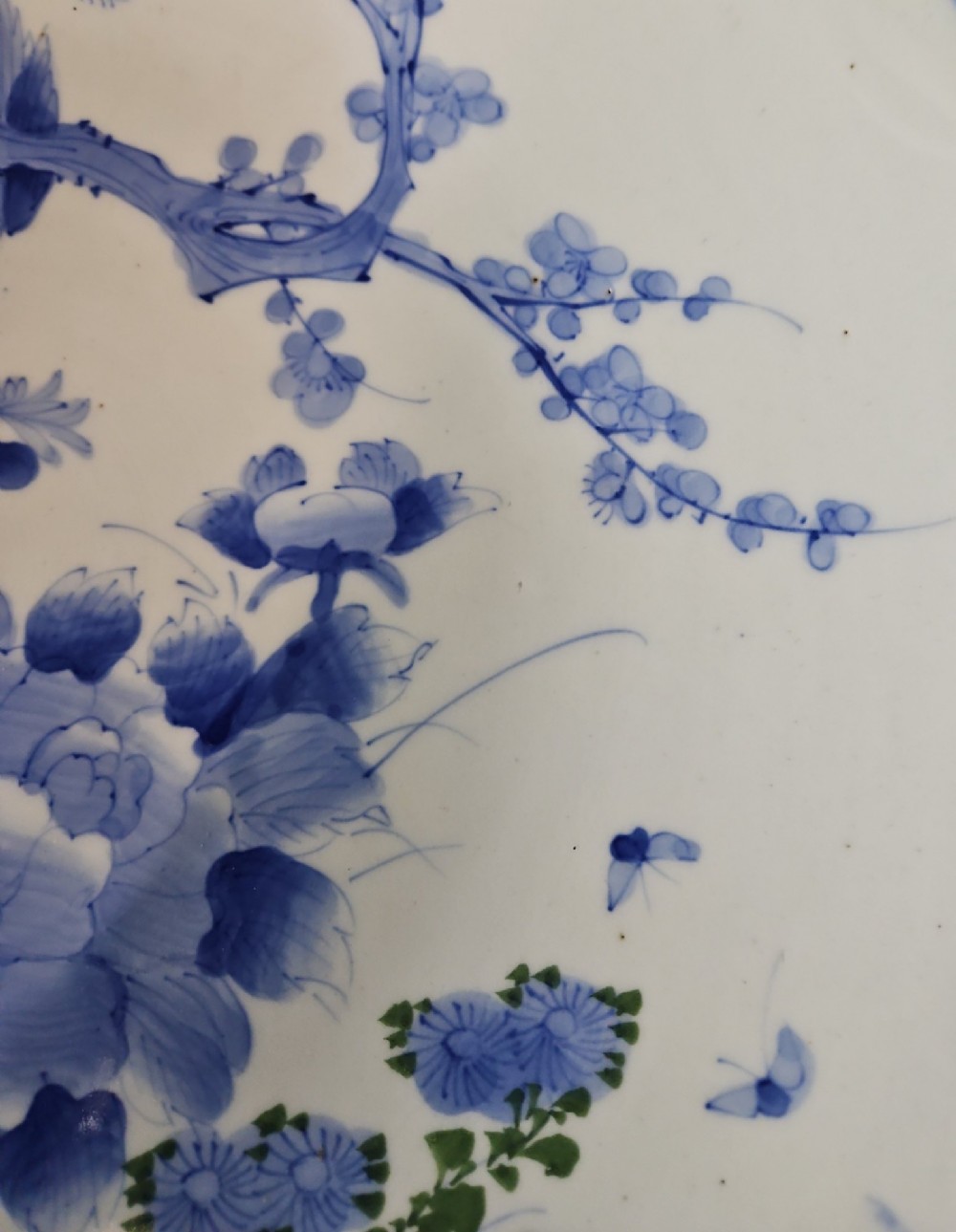 A circular blue and white Japanese Arita porcelain charger decorated with a flowering prunus branch and chrysanthemum blossoms. View VII