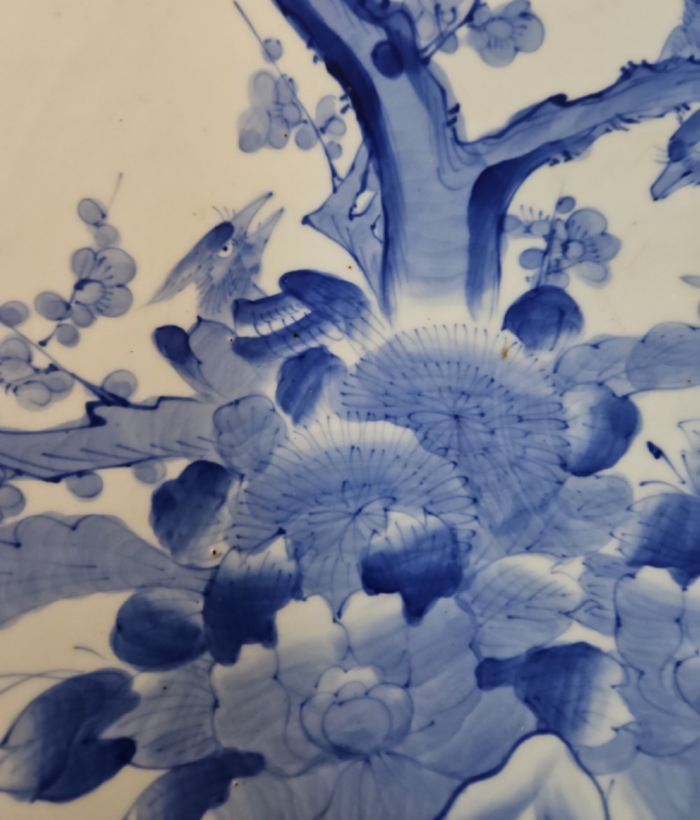 A circular blue and white Japanese Arita porcelain charger decorated with a flowering prunus branch and chrysanthemum blossoms. View X