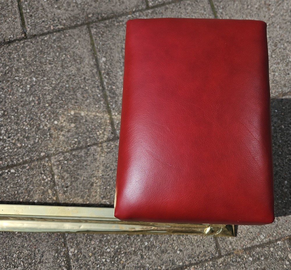 A Victorian brass club fender featuring a polished metal frame with upright supports and two red leather buttoned seats. View II