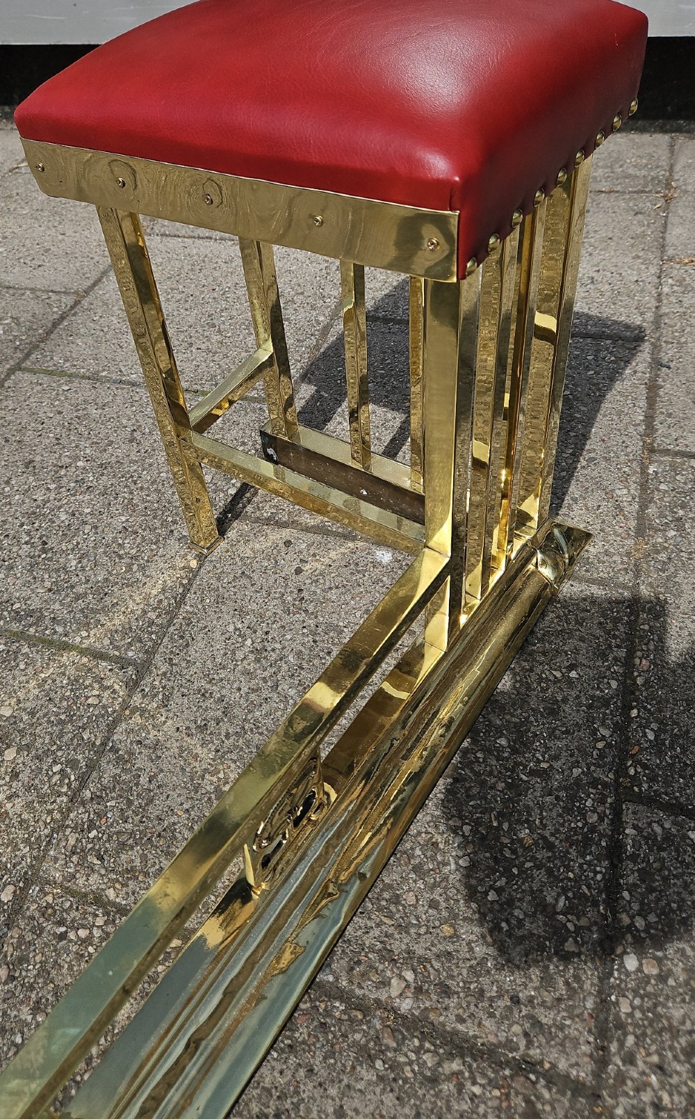 A Victorian brass club fender featuring a polished metal frame with upright supports and two red leather buttoned seats. View IV