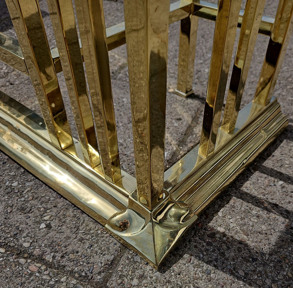 A Victorian brass club fender featuring a polished metal frame with upright supports and two red leather buttoned seats. View VIII