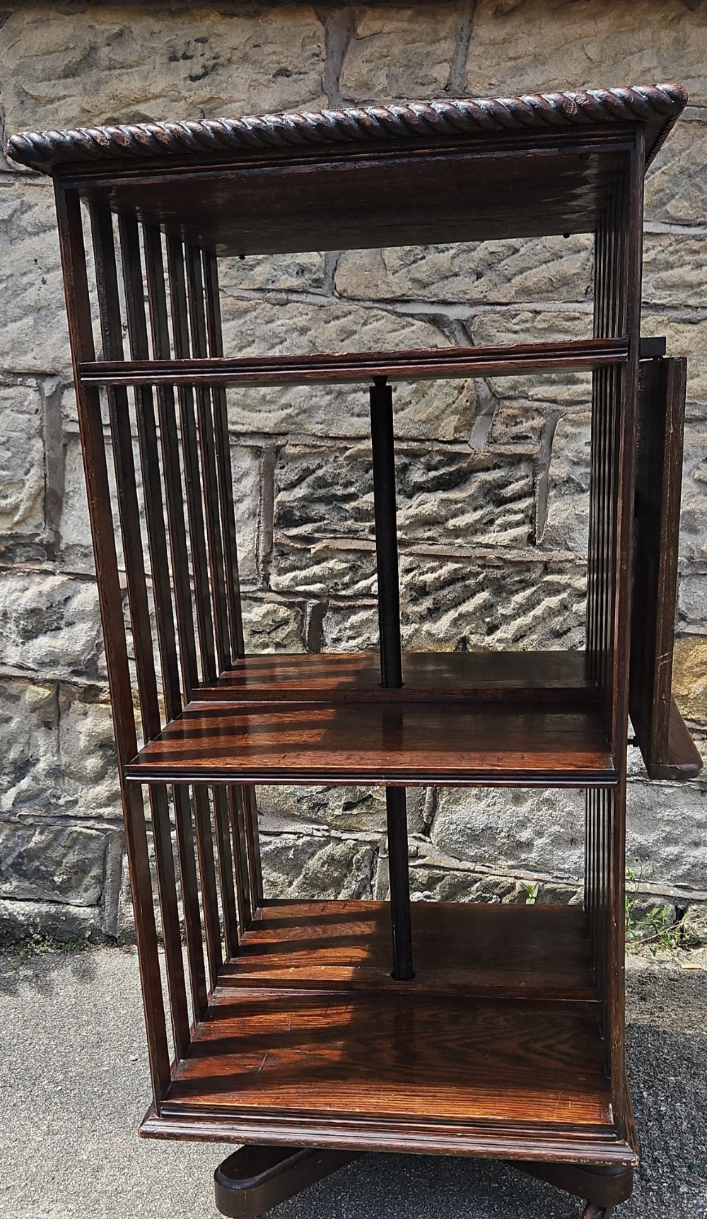 An Edwardian oak revolving bookcase shown disassembled alongside its central cast iron post and quadform wooden base. View IV