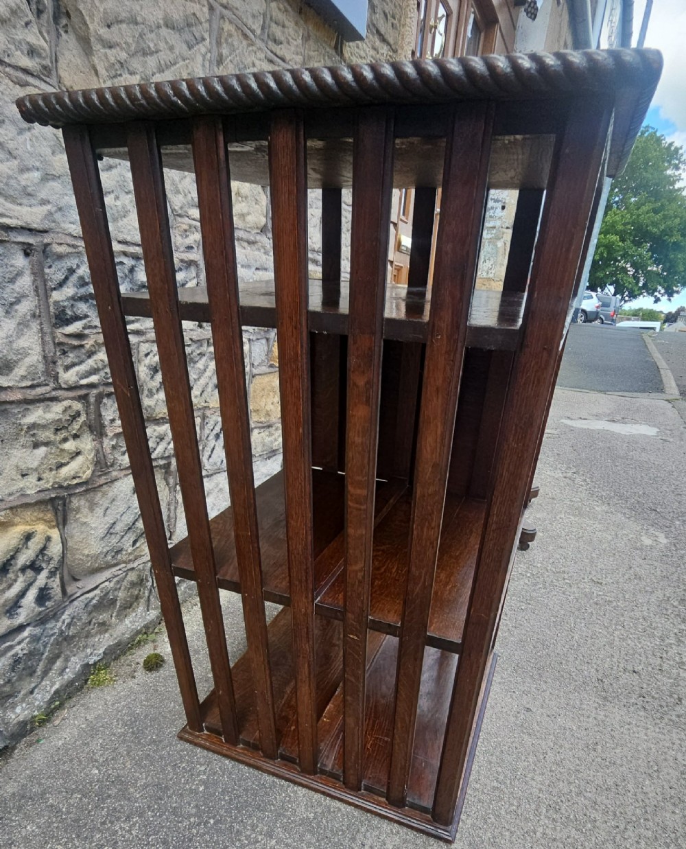 An Edwardian oak revolving bookcase shown disassembled alongside its central cast iron post and quadform wooden base. View V