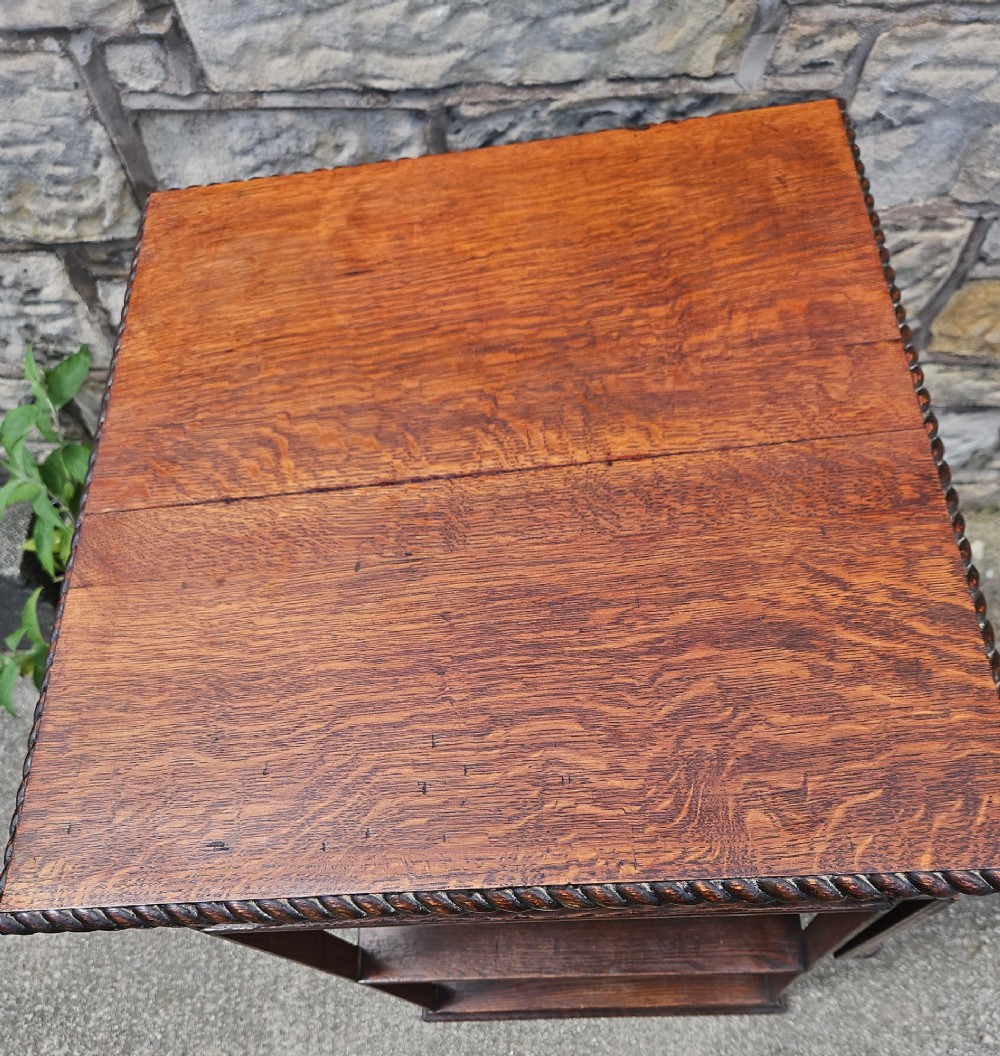 An Edwardian oak revolving bookcase shown disassembled alongside its central cast iron post and quadform wooden base. View VI