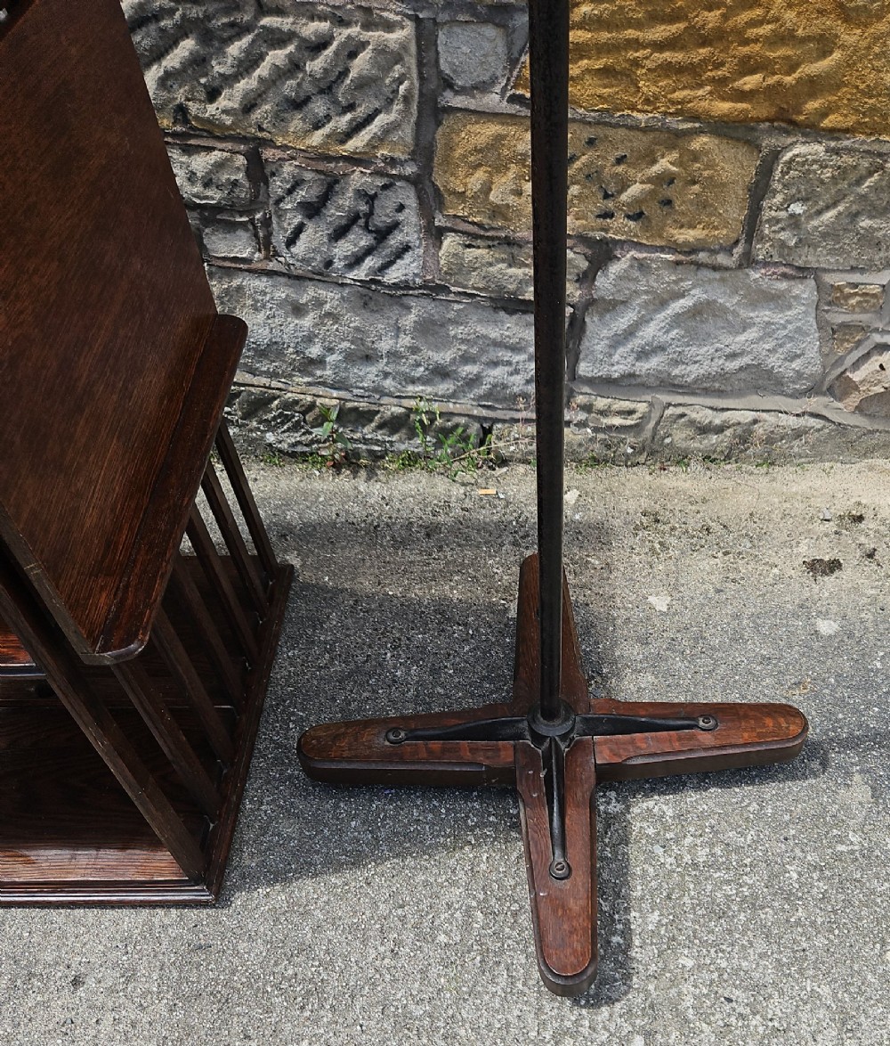 An Edwardian oak revolving bookcase shown disassembled alongside its central cast iron post and quadform wooden base. View VIII