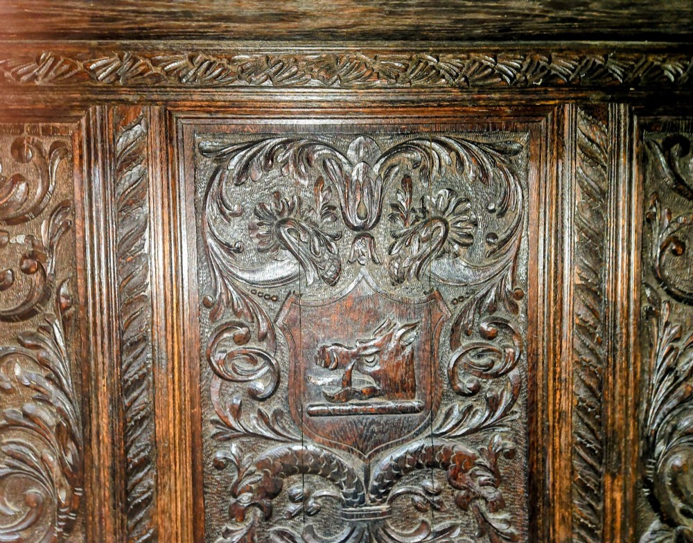 A heavily carved dark oak Jacobean style dresser featuring an open tiered upper rack supported by barley twist columns over a three-door base cupboard with carved relief panels. View III