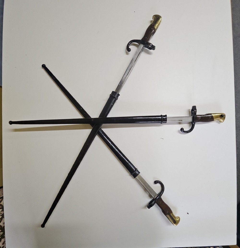 A late 19th-century French military bayonet hilt with a brass pommel, walnut handle scales, a curved steel quillon, and a metal scabbard. View II