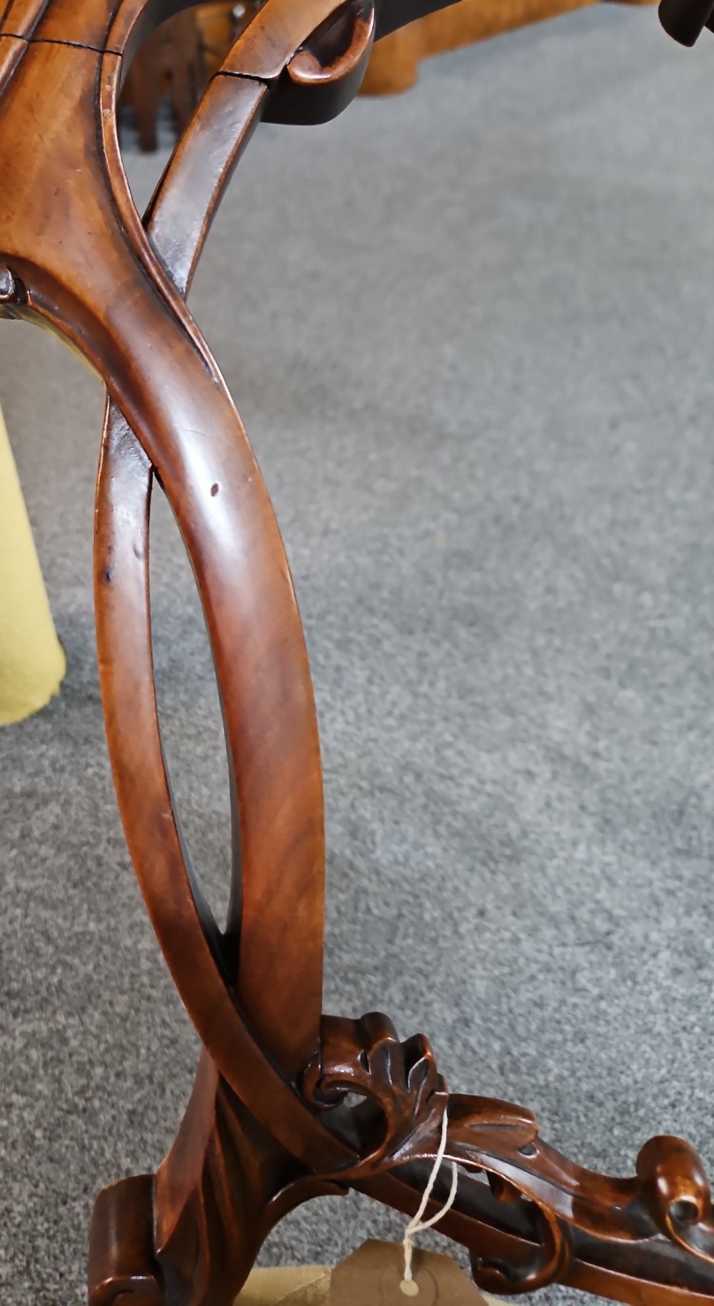 A set of four Victorian carved walnut chairs featuring intricate openwork scroll backrests, patterned cream upholstery, and cabriole legs. View V