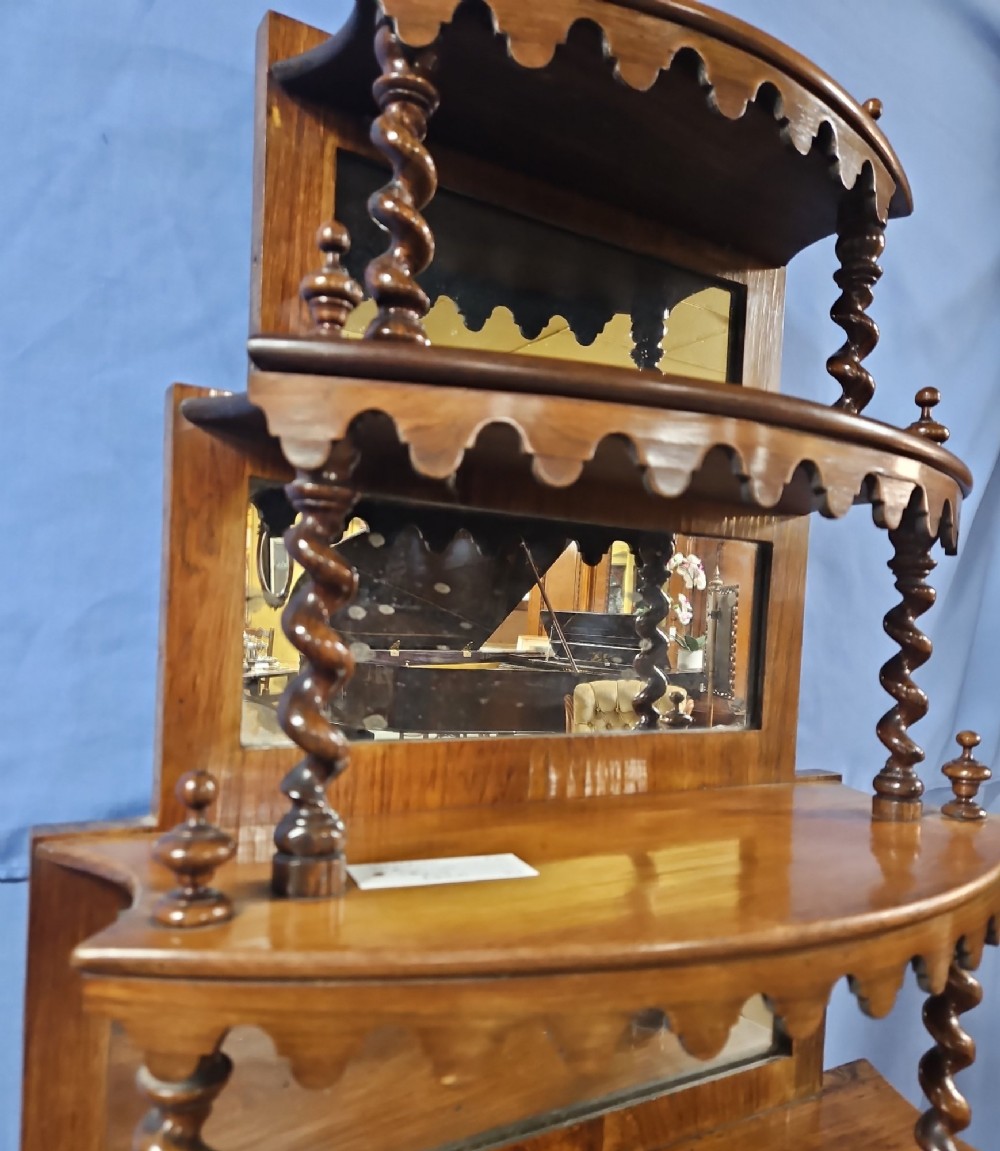 A multi-tiered Victorian rosewood etagere featuring barley twist supports, scalloped shelf aprons, and inset mirrored panels. View VI