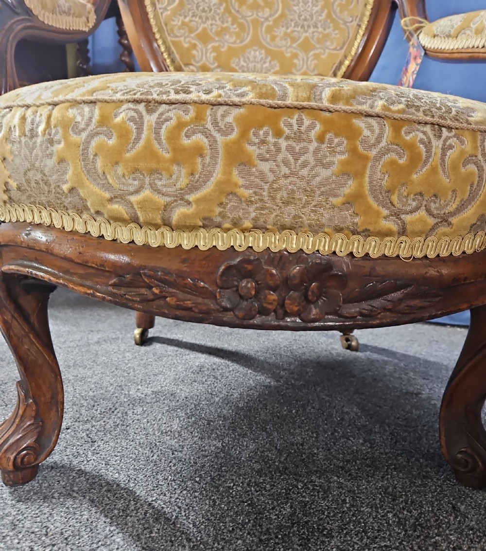A Victorian walnut salon armchair with a carved wood frame, oval padded backrest, and yellow damask upholstered seat and armrests. View III