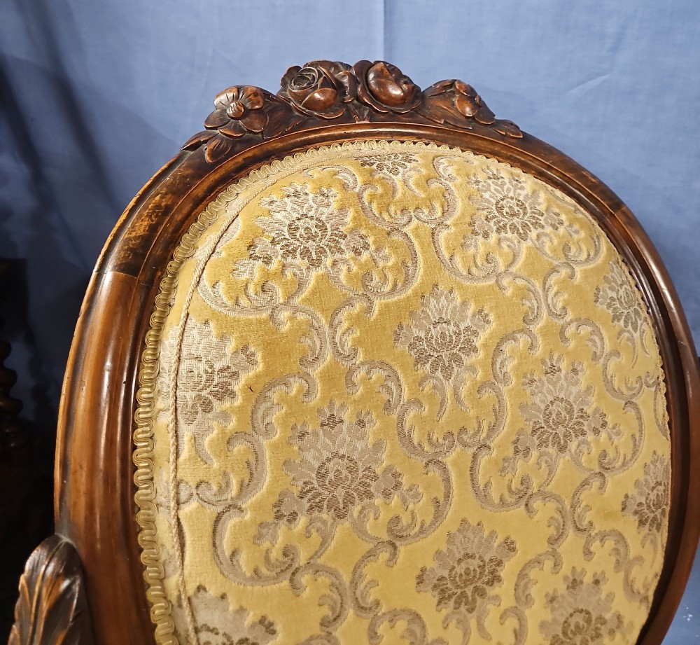 A Victorian walnut salon armchair with a carved wood frame, oval padded backrest, and yellow damask upholstered seat and armrests. View IV