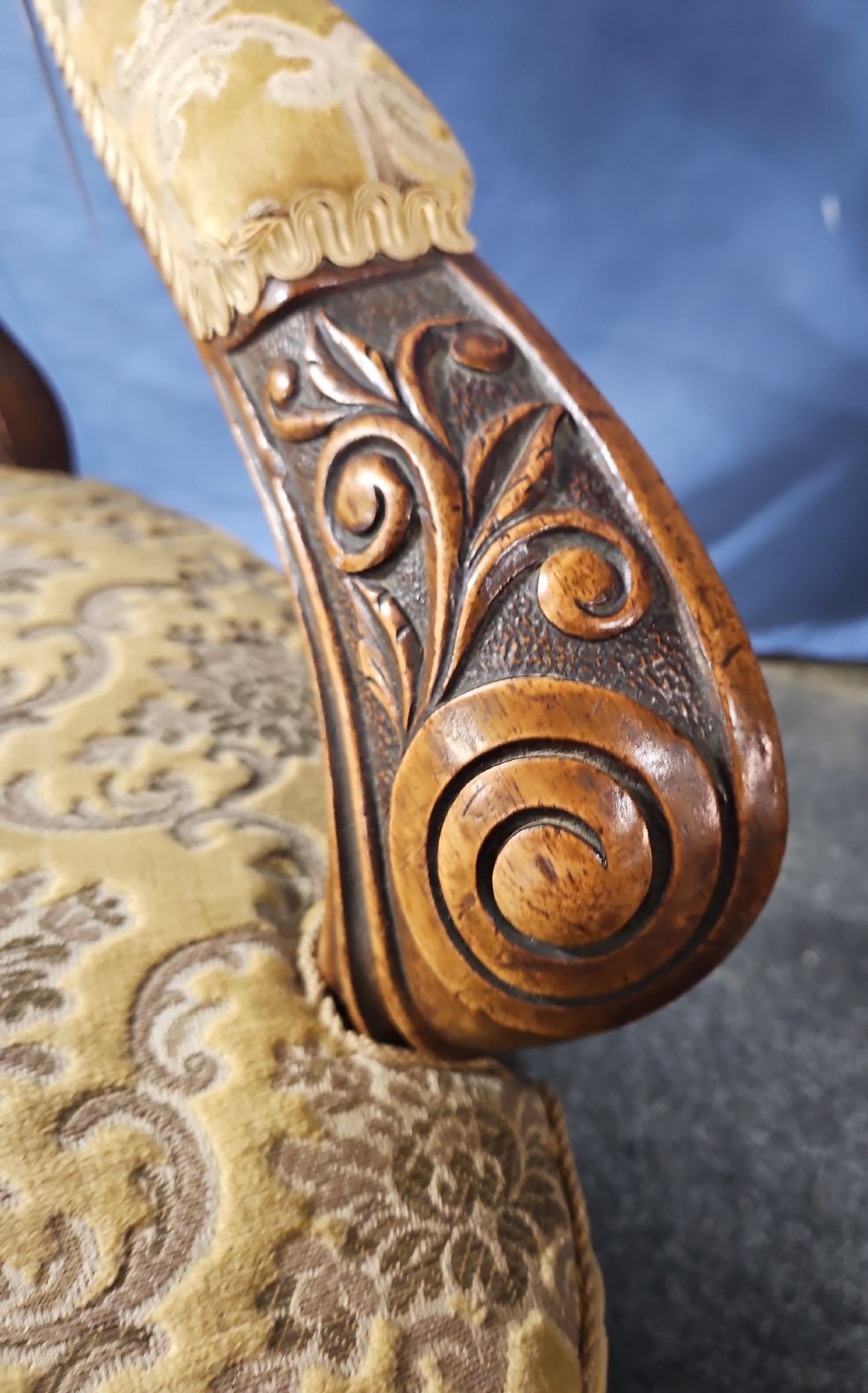 A Victorian walnut salon armchair with a carved wood frame, oval padded backrest, and yellow damask upholstered seat and armrests. View V