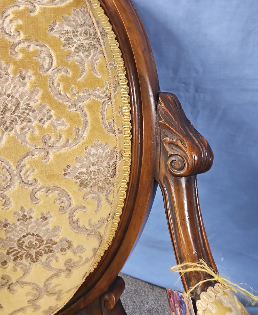A Victorian walnut salon armchair with a carved wood frame, oval padded backrest, and yellow damask upholstered seat and armrests. View VI