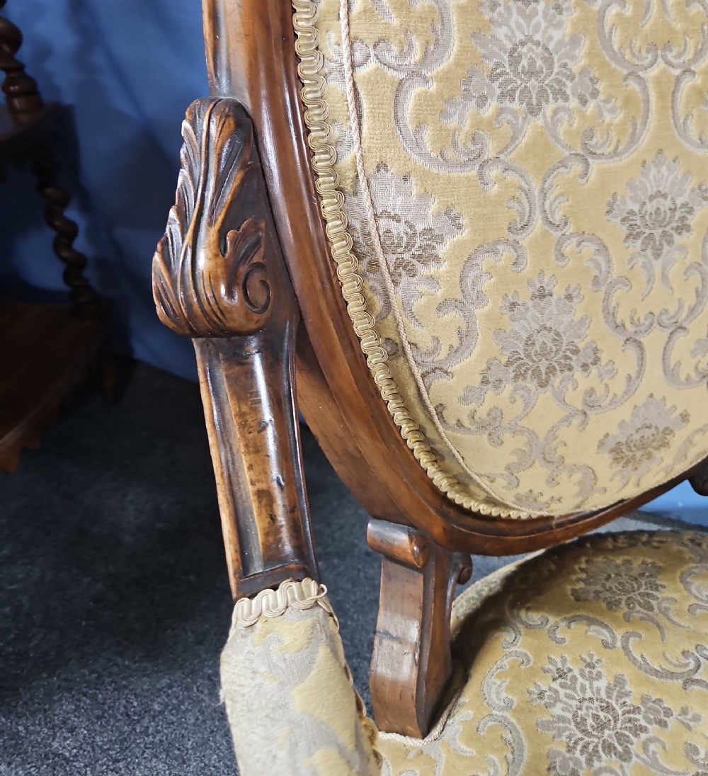 A Victorian walnut salon armchair with a carved wood frame, oval padded backrest, and yellow damask upholstered seat and armrests. View VII