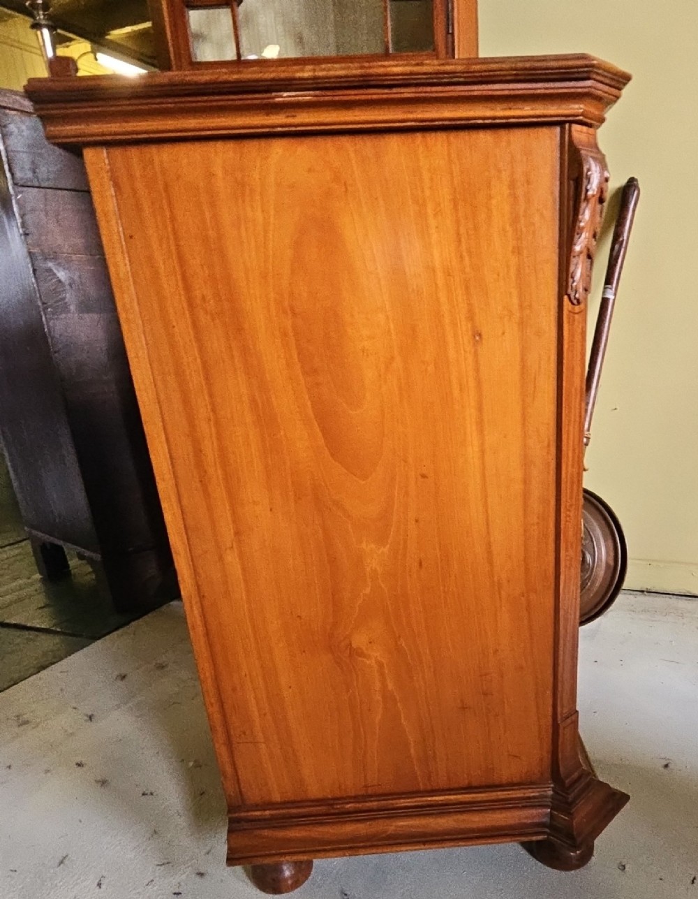 A single door satinwood bedside cabinet featuring detailed floral marquetry inlay on the panel, carved upper corbels, and a brass drop handle. View IV