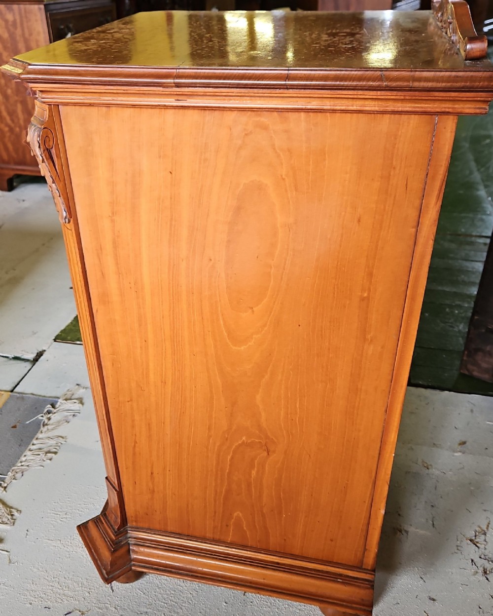 A single door satinwood bedside cabinet featuring detailed floral marquetry inlay on the panel, carved upper corbels, and a brass drop handle. View V