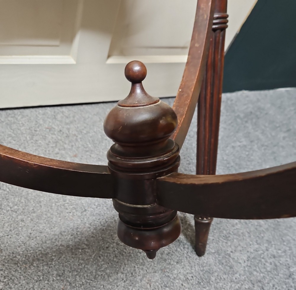 A dark mahogany circular globe stand featuring three fluted turned legs and a worn printed paper horizon ring. View IV