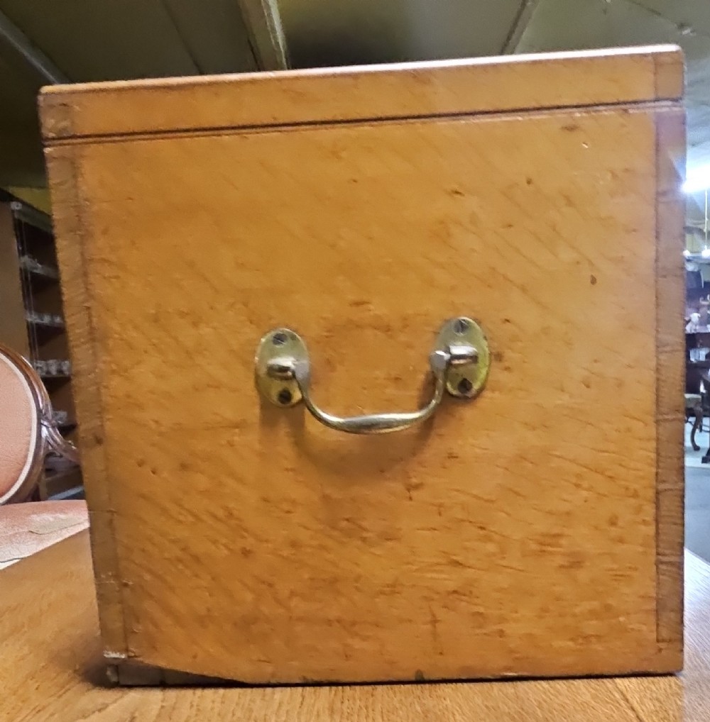 A rectangular light wooden antique storage box featuring visible dovetail corner joints and a central brass keyhole. View II