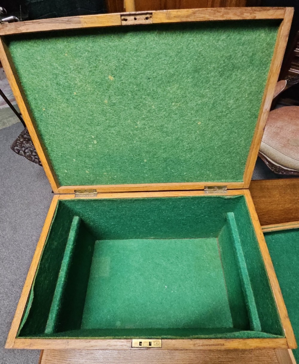 A rectangular light wooden antique storage box featuring visible dovetail corner joints and a central brass keyhole. View III