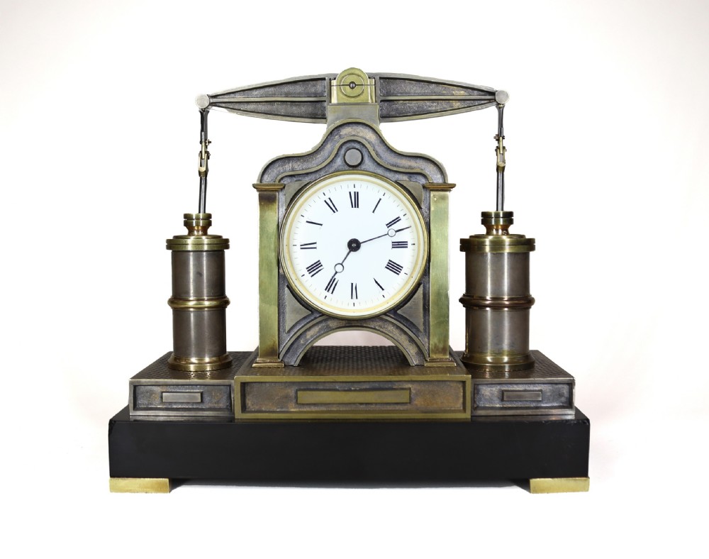 An industrial French automaton clock designed in the shape of a steam beam engine with brass and dark bronze components set on a black slate plinth.
