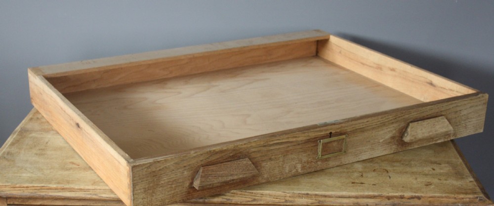 A light oak six-drawer plan chest featuring angled wooden handles and central brass label plates. View V